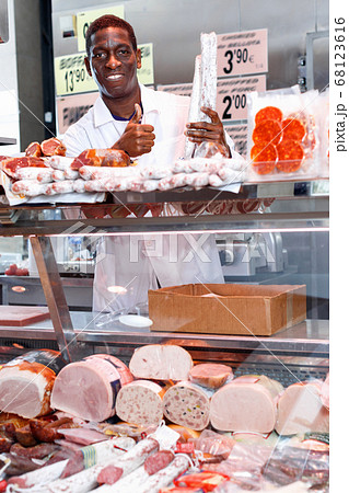Successful butcher shop owner giving thumbs up, satisfied with quality of meat products Successful butcher shop owner giving thumbs up, satisfied with quality of meat products 68123616