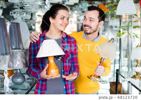 Smiling man and girl in lighter shop choose desk lamp Smiling man and girl in lighter shop choose desk lamp 68123720