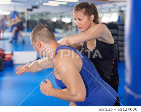 Active girl exercise fight with man trainer in gym 68124000