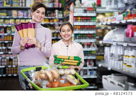 Glad woman with girl choosing delicious pasta 68124573