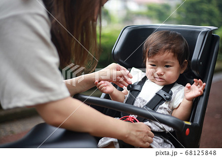 自転車用チャイルドシートを嫌がる女の子の写真素材