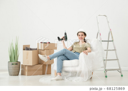Smiling woman in room with moving boxes 68125869