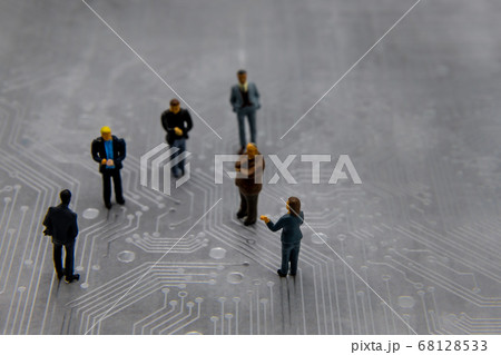 Miniature figurines posed as business people in a 68128533
