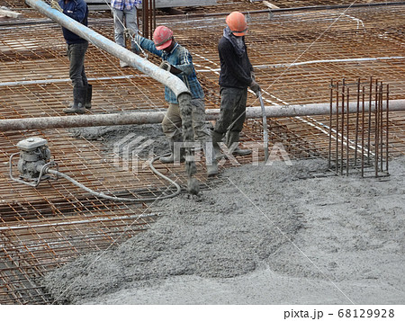 KUALA LUMPUR, MALAYSIA -SEPTEMBER 24, 2017: Construction workers puoring wet concrete using hose from the elephant crane or concrete pump crane at the construction site. KUALA LUMPUR, MALAYSIA -SEPTEMBER 24, 2017: Construction workers puoring wet concrete using hose from the elephant crane or concrete pump crane at the construction site. 68129928