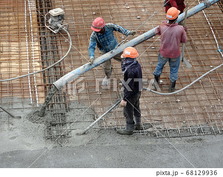 KUALA LUMPUR, MALAYSIA -SEPTEMBER 24, 2017: Construction workers puoring wet concrete using hose from the elephant crane or concrete pump crane at the construction site. 68129936