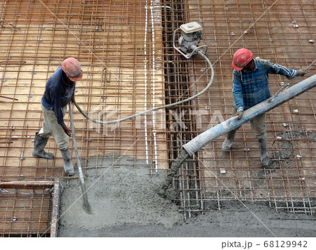 KUALA LUMPUR, MALAYSIA -SEPTEMBER 24, 2017: Construction workers puoring wet concrete using hose from the elephant crane or concrete pump crane at the construction site. 68129942