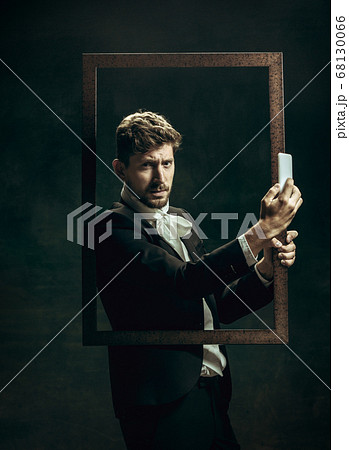 Young man as Dorian Gray on dark background. Retro style, comparison of eras concept. 68130066