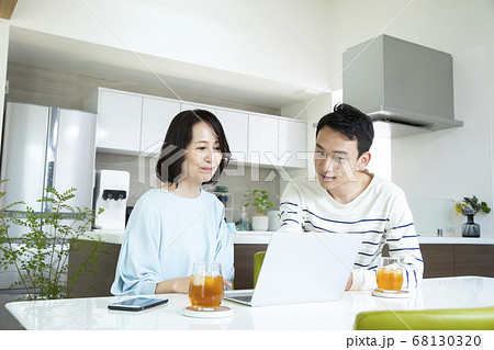 親子 一緒にパソコンを見る若い男性とミドル女性 親子 一緒にパソコンを見る若い男性とミドル女性 68130320