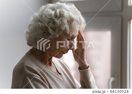 Elderly woman closed eyes touch forehead suffers from severe headache Elderly woman closed eyes touch forehead suffers from severe headache 68130528