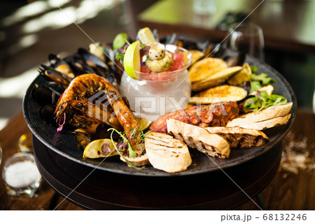 Seafood platter for 2-4 persons. Octopus, blue mussels, cooked green mussels, grilled tiger prawns, tuna tartare. Delicious seafood closeup served on a table for lunch in modern gourmet restaurant 68132246