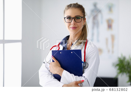 Medical officer smiles and holds clipboard in his hands. Medical officer smiles and holds clipboard in his hands. 68132802