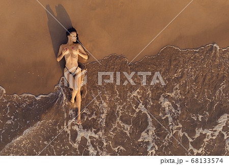 Aerial view sexy naked woman lying on sand 68133574