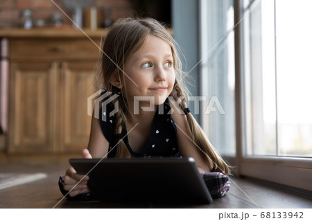 Little Caucasian girl relax on floor using tablet Little Caucasian girl relax on floor using tablet 68133942