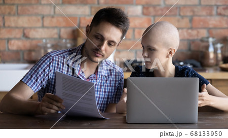 Young couple with sick wife pay bills on laptop 68133950