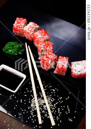 Sushi with salmon. Soy sauce, red caviar. Sushi on a black background. Sushi with salmon. Soy sauce, red caviar. Sushi on a black background. 68134233