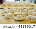 Homemade Dumplings lie on the baking tray in rows 68136017