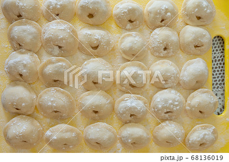 Homemade Dumplings lie on the baking tray in rows 68136019