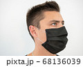 Black protective mask on the young guy's face, portrait 68136039