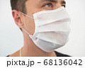 White protective mask on the young guy's face, portrait 68136042
