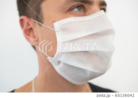 White protective mask on the young guy's face, portrait White protective mask on the young guy's face, portrait 68136042
