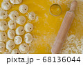 Homemade Dumplings lie on the baking tray in rows with rolling pin for dough 68136044