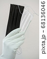 Man holds rubber gloves black and white face masks 68136046