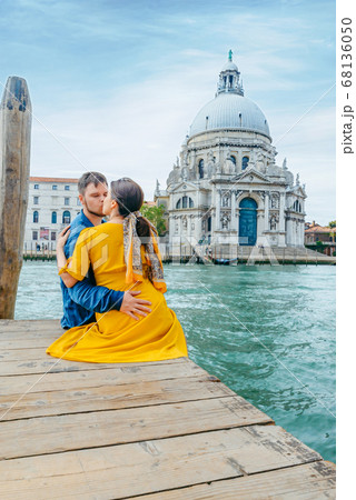 couple hugging on pier with view of grand canal saint maria church on background 68136050