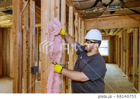 Hand in gloves holding mineral wool, building 68140755