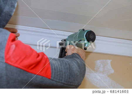 Installation of crown moldings trim on the ceiling Installation of crown moldings trim on the ceiling 68141603