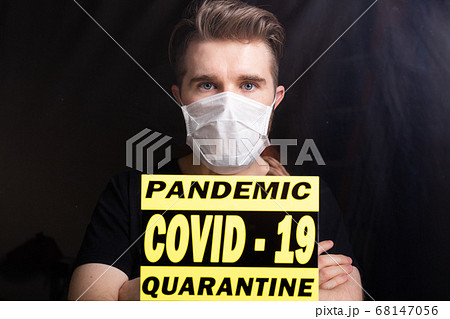 Coronavirus, quarantine, covid-19 and pandemic concept. Sad and sick man of corona virus looking through the window. Stay at home. Coronavirus, quarantine, covid-19 and pandemic concept. Sad and sick man of corona virus looking through the window. Stay at home. 68147056