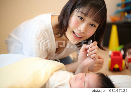 赤ちゃんの耳掃除をする母親の写真素材