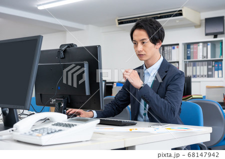 新型コロナ予防のためリモートワーク になり、1人でオフィスで仕事をする若いビジネスマン 新型コロナ予防のためリモートワーク になり、1人でオフィスで仕事をする若いビジネスマン 68147942