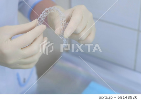 Silicone invisible transparent braces in orthodontist doctor hands in dentistry. 68148920