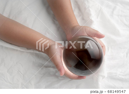 Hand holding a crystal glass ball transparent on 68149547
