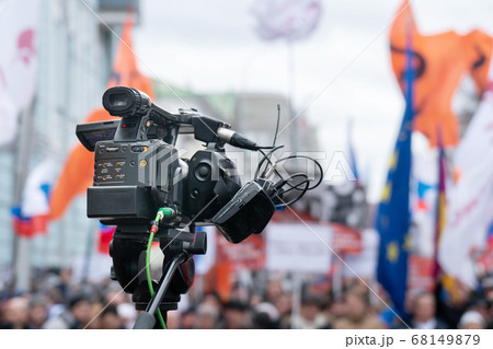 Videographer's camera is reporting from a city street during a mass political action 68149879