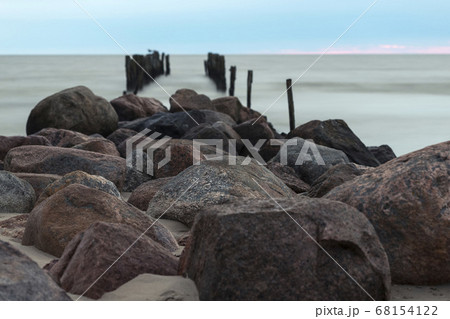 Remains of an old pier, old breakwater posts on beach, Lapmezciems, Latvia Remains of an old pier, old breakwater posts on beach, Lapmezciems, Latvia 68154122