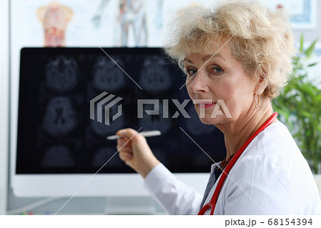 Elderly woman doctor shows pen on x-ray Elderly woman doctor shows pen on x-ray 68154394