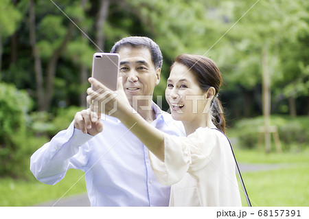 スマホで写真を撮る笑顔のシニア夫婦 68157391