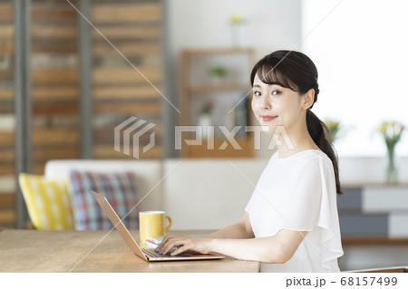 リビングでパソコンを使う若い女性 68157499