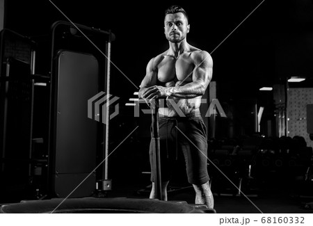 Monochrome portrait of man holding sledgehammer. 68160332