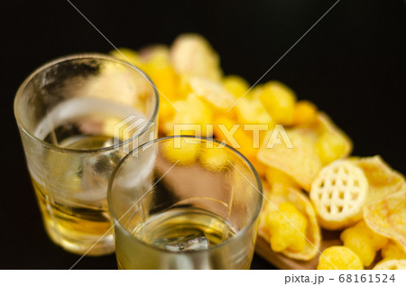 glass of whiskey with ice cubes and salty snacks glass of whiskey with ice cubes and salty snacks 68161524