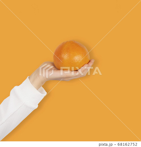 Female hand holds bright orange grapefruit fruit Female hand holds bright orange grapefruit fruit 68162752