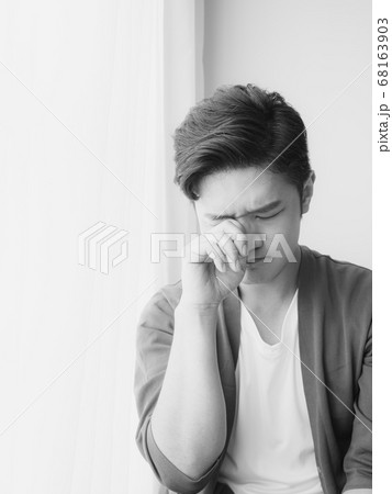 Young asian man rubbing his eyes 68163903