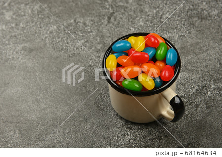 Multicolor jelly beans in mug on table 68164634