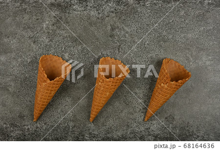 Three empty wafer ice cream cones on gray table 68164636