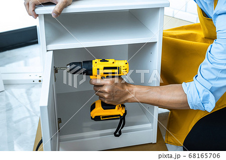 Man doing renovation work at home drilling wood Man doing renovation work at home drilling wood 68165706
