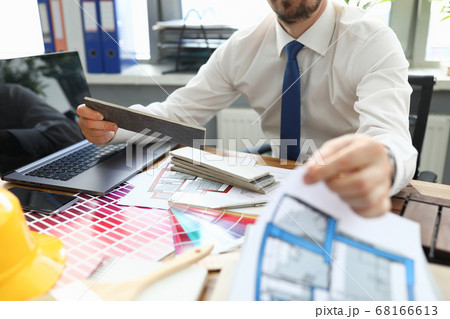 Man sits at a table with devices and color scheme Man sits at a table with devices and color scheme 68166613