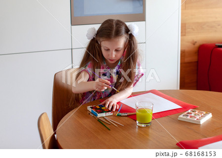 7 years old girl draws with watercolors. Close-up.  68168153