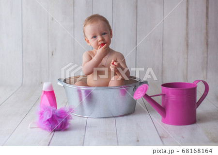 One year old baby girl takes a bath.  68168164