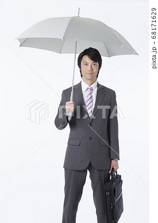 傘を差すビジネスマンの写真素材
